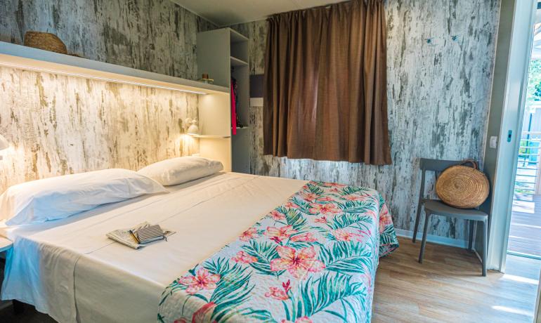 Gemütliches Zimmer mit Doppelbett und bunten Blumendekorationen.