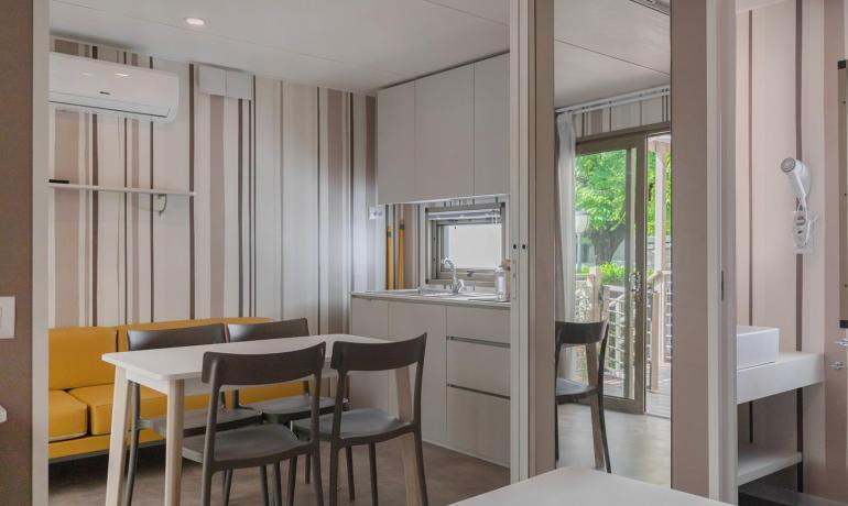Moderno appartamento con cucina, tavolo da pranzo e balcone.