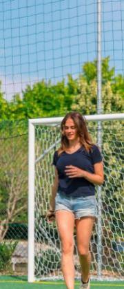Girl playing soccer on an outdoor field.