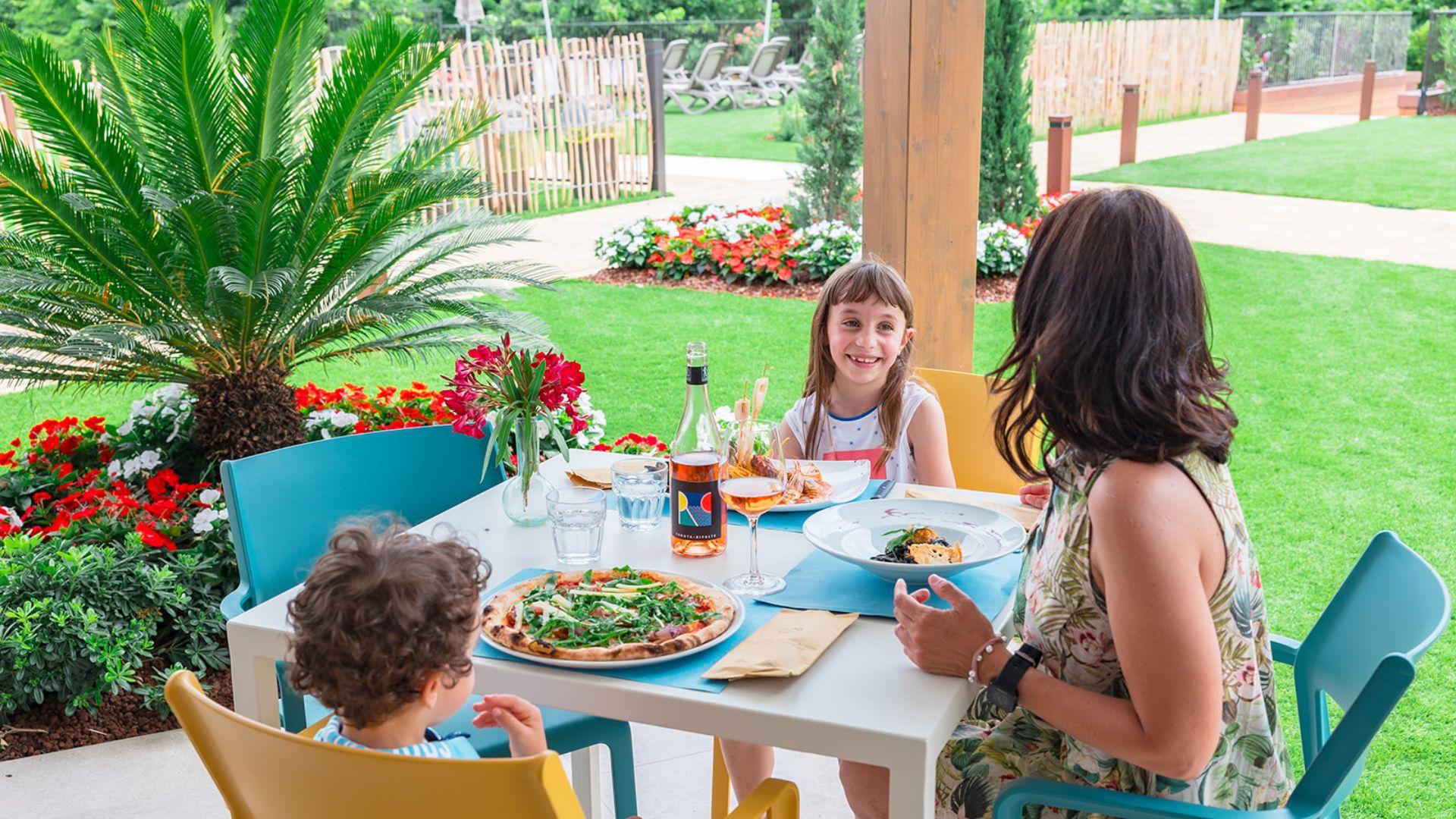 Family having lunch outdoors in a garden.