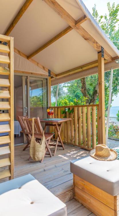 Gemütliche Veranda mit Tisch, Stühlen und Gartenblick.