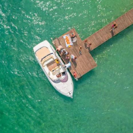 Boat docked at a pier with people relaxing.