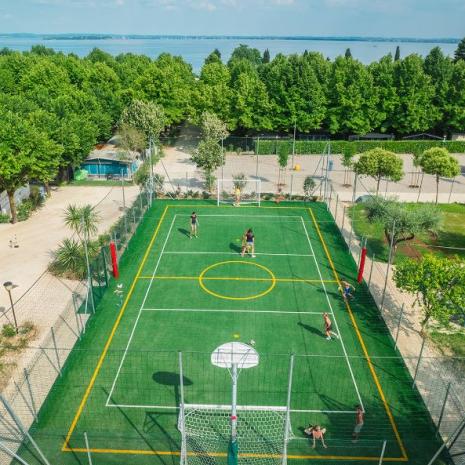 Outdoor sports field near the lake, surrounded by trees.