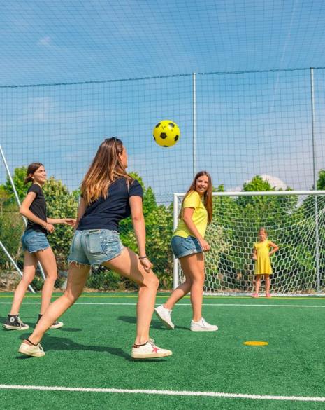 Girls playing soccer on an outdoor field.