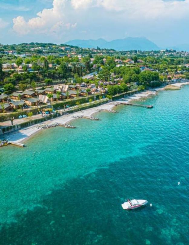 Aerial view of a coastline with turquoise waters and a green landscape.