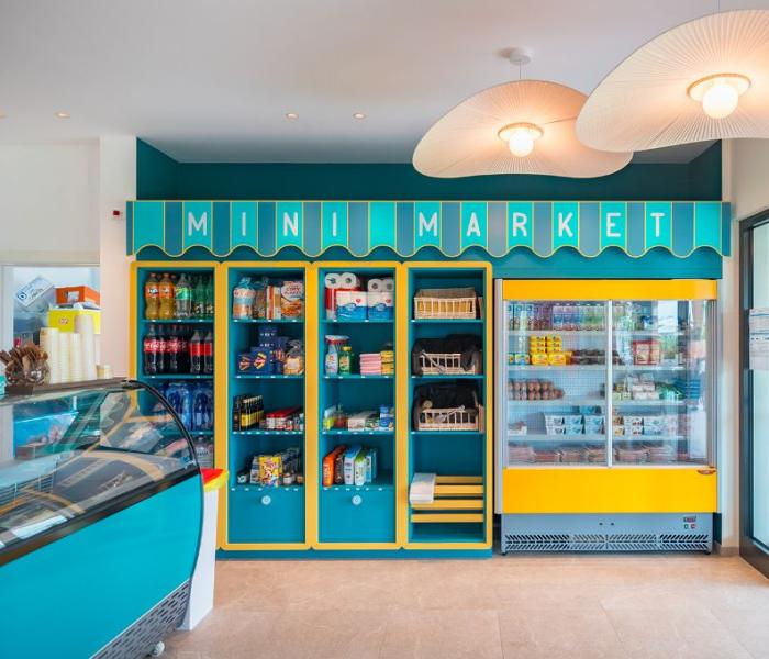 Small minimarket with colorful shelves and a refrigerator.