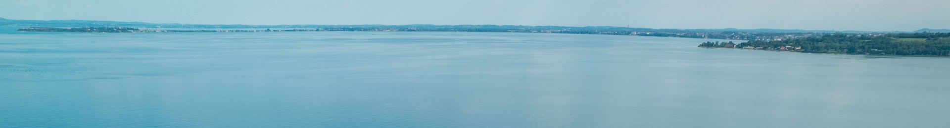 Panoramablick auf einen See mit entfernter Küste.